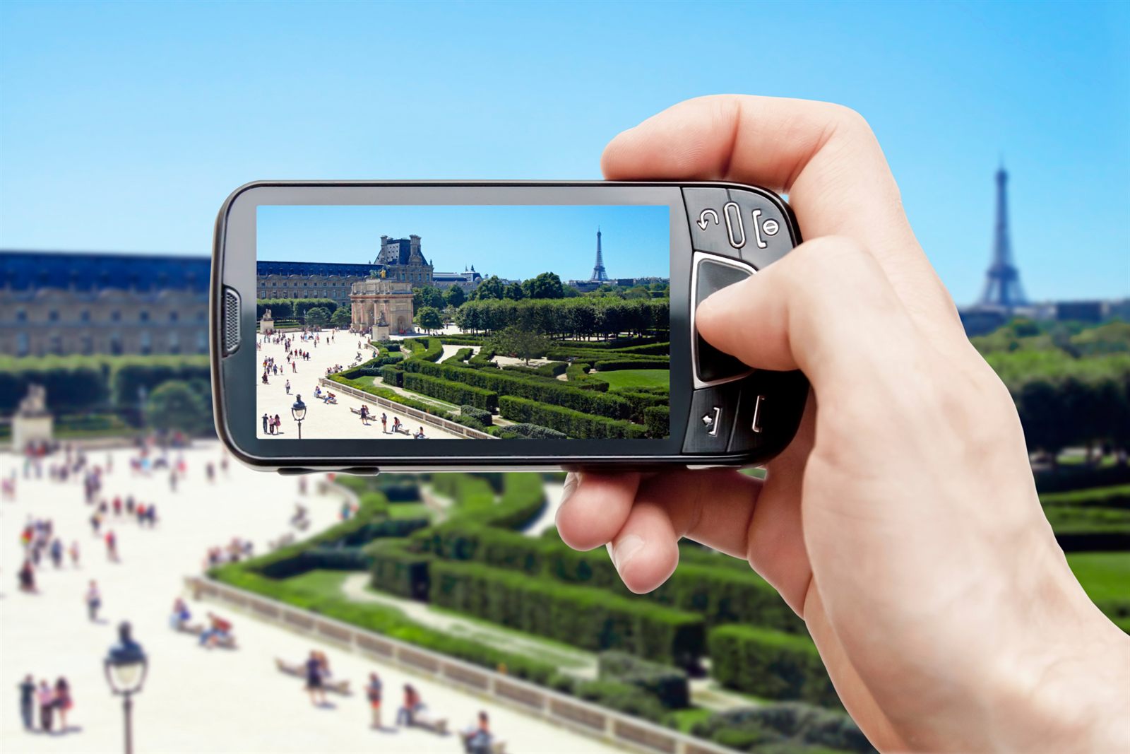 Hands holding a smartphone up to photograph a city view, the way travelers use cruise apps ashore