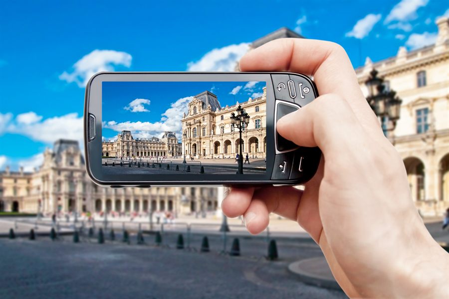 Smartphone held up to photograph a city square